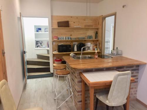 une cuisine avec un comptoir, une table et des chaises dans l'établissement La cremaillère, à Huriel