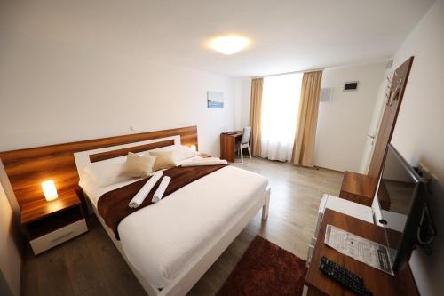 a bedroom with a large bed and a television at Hotel Murter in Murter