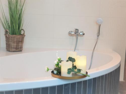 a candle in a bath tub with a plant at Penthouse Gezeitenblick, Am Alten Deich 4-2 31 in Dangast