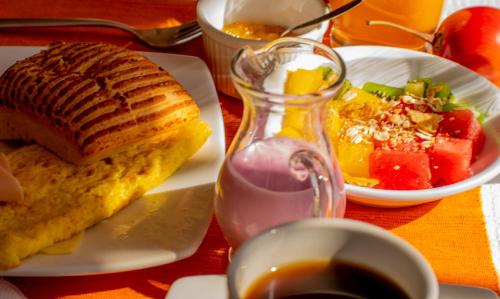 a breakfast plate with a sandwich and a bowl of fruit at Hotel Rincon Aleman in Riobamba