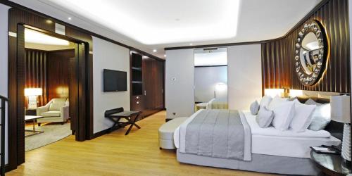 a bedroom with a large white bed and a living room at Crowne Plaza Bursa Convention Center & Thermal Spa by IHG in Bursa