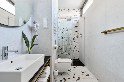 a bathroom with a shower and a toilet and a sink at Hotel Liberte 33 BW Premier Collection in Poznań
