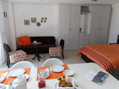a bedroom with a bed and a table and chairs at Hotel Rincon Aleman in Riobamba