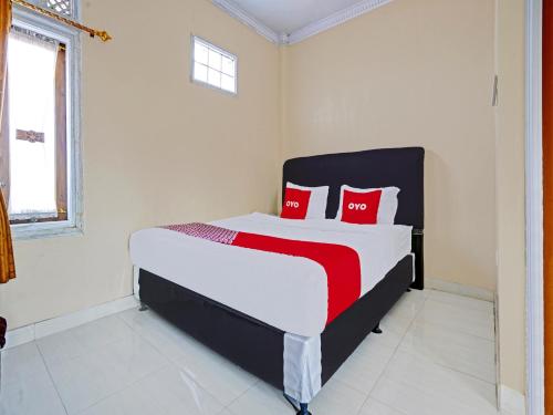 ein Schlafzimmer mit einem großen Bett mit roten Kissen in der Unterkunft OYO 90416 Wisma Wayang Ajen Syariah in Subang