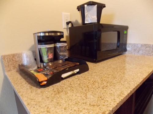 a kitchen counter with a coffee maker and a microwave at AmeriVu inn and Suites - Crookston in Crookston