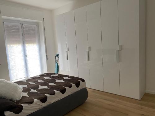 a bedroom with a bed and a large white cabinet at HOME LEOPARDI humanitas,forum,ieo INTERO APPARTAMENTO in Rozzano