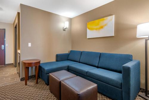 a living room with a blue couch and a table at Comfort Suites Broomfield-Boulder-Interlocken in Broomfield