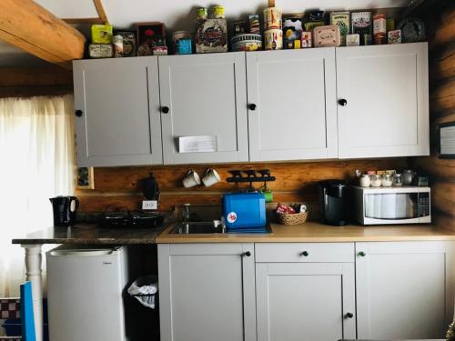 a kitchen with white cabinets and a counter top at Jade Fever Cabina in Jade City
