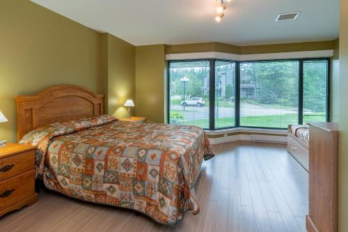 En eller flere senge i et værelse på Condo 2 chambres avec parc aquatique!