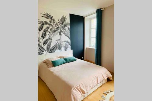 1 dormitorio con 1 cama con papel pintado tropical en La roseraie de L arguenon, appartement charmant centre ville, en Jugon Les Lacs
