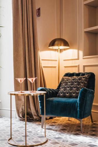 a living room with a blue couch and two tables at Palazzo 42 - Boutique Hotel & Suites in Pistoia