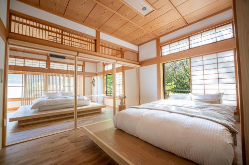 a bedroom with a large bed and large windows at プライベートリゾート 月灯 in Atami