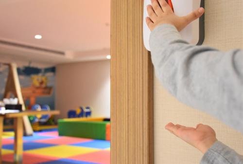 a child is looking into a mirror in a room at Midan Hotel & Suites Al Aziziya in Makkah