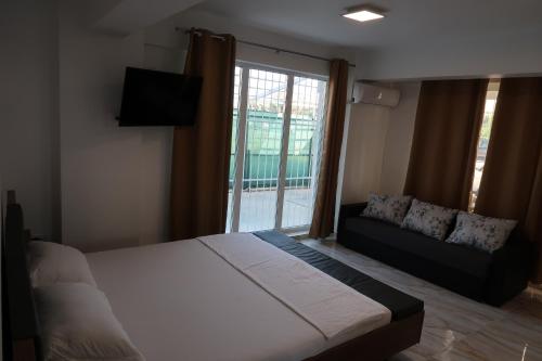 - une chambre avec un lit, un canapé et une fenêtre dans l'établissement Home Space One, à Mamaia Nord – Năvodari