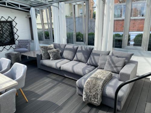 a living room with a gray couch and chairs at Apartment Factory in Hamburg