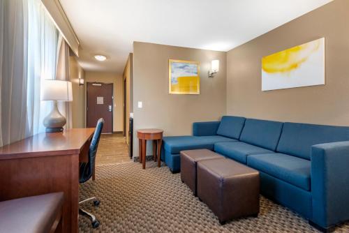 a living room with a blue couch and a desk at Comfort Suites Broomfield-Boulder-Interlocken in Broomfield