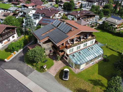 an aerial view of a house with a solar roof at Wellness Pension Hollaus in Kirchberg in Tirol