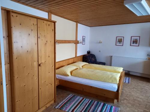 a bedroom with two beds and a wooden closet at Haus Beckenbauer in Sankt Michael im Lungau