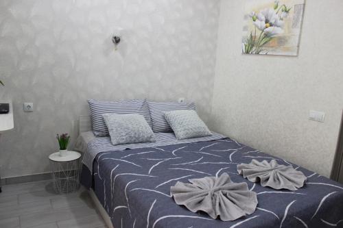 a bedroom with a bed with a blue comforter and pillows at Apartments in Kharkiv in Kharkiv