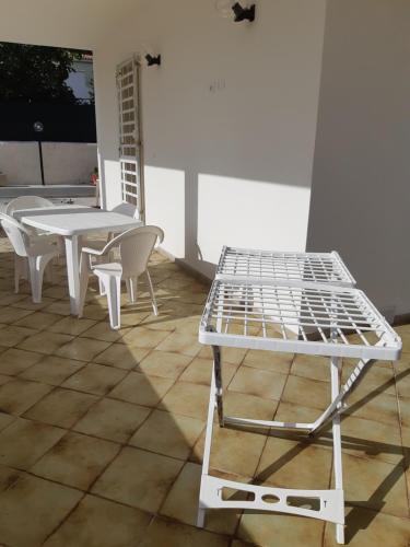 - un lit, des tables et des chaises sur la terrasse dans l'établissement Fronte Mare, à Avola