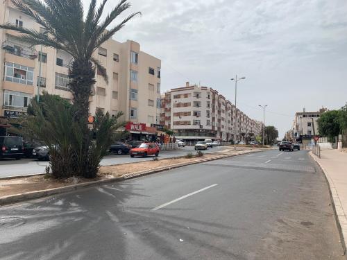 een lege straat met een palmboom en gebouwen bij دار الضيافة Dar Diafa Essalam in Agadir