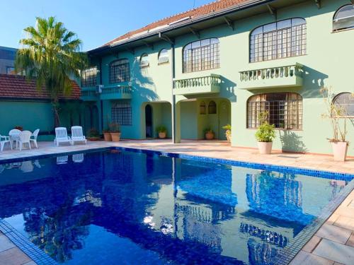 una casa con piscina frente a ella en Vila Verde Hotel, en Toledo