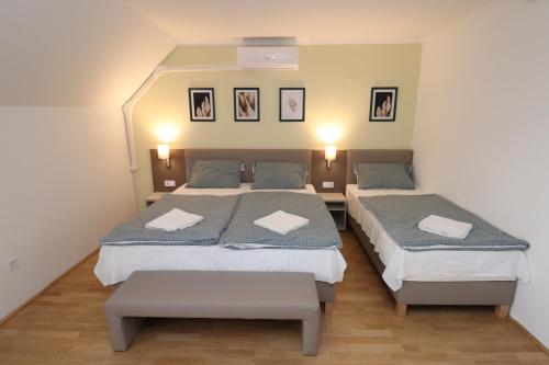 a bedroom with two beds and two benches in it at Villa Galagonya I. II. in Balatongyörök