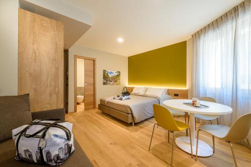 een hotelkamer met een bed en een tafel en stoelen bij SANMARTINO SUITE in Tirano