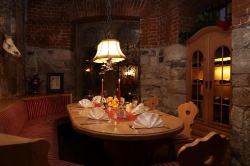 a dining room with a table and a lamp at Parkhotel Altes Kaffeehaus in Wolfenbüttel