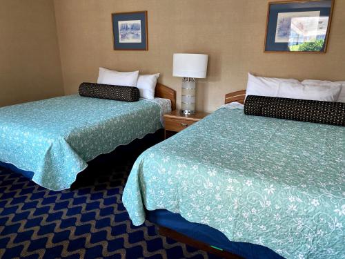 a hotel room with two beds next to each other at Economy Lodge 682 Main St Sturbridge in Sturbridge