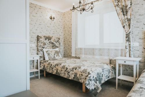 a bedroom with a bed and two tables and a window at Van Vila in Klaipėda