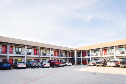 a large building with cars parked in a parking lot at Palace Inn and Suites Baytown in Baytown