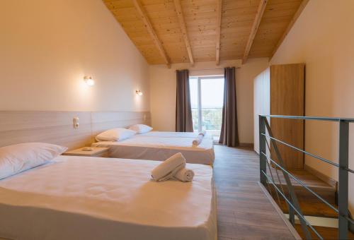 a hotel room with two beds and a window at Luca Mare in Gouvia