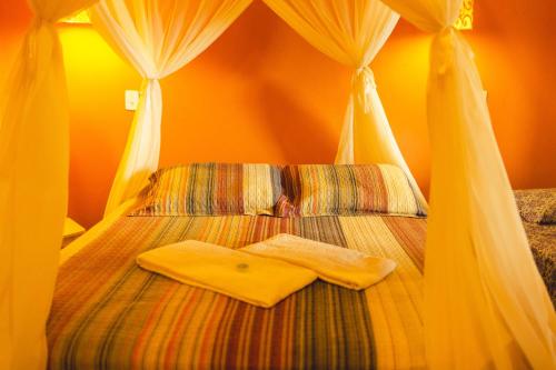 a bedroom with a bed with two towels on it at Vila Clara do Capão in Vale do Capao