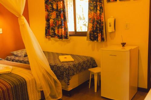 a small bedroom with two beds and a window at Vila Clara do Capão in Vale do Capao