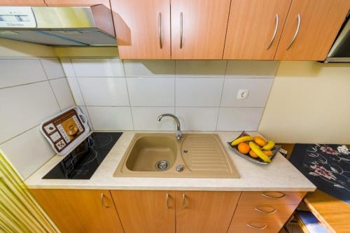 a kitchen counter with a sink with fruit on it at Apartment Vrsi at the Beach in Vrsi