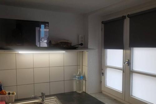 una cucina con lavandino, finestra e bancone di petit studio pour une personne à Lobsann a Lobsann