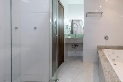 y baño con ducha y lavamanos. en Hotel Ilha da Madeira, en Balneário Camboriú
