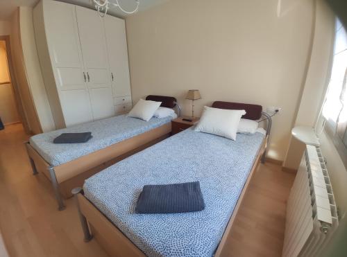 2 Betten in einem kleinen Zimmer mit in der Unterkunft Apartamento El Falcar in Villanúa