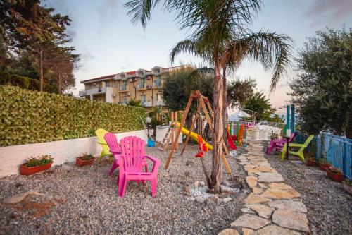 a playground with colorful chairs and a swing at Hotel Piccolo Mondo in Acquappesa