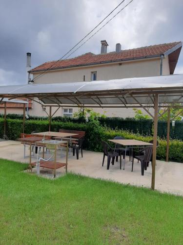 a group of tables and chairs under a pavilion at Guest House Valiland in Bŭlgarevo