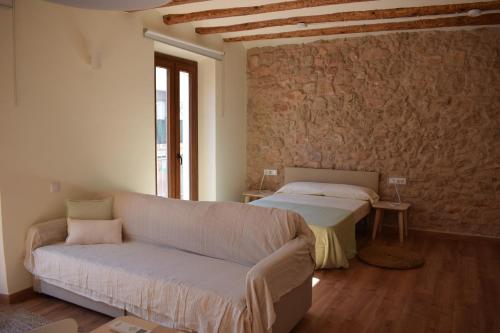 uma sala de estar com um sofá e uma cama em Apartaments Casa el Metge em Prat de Comte