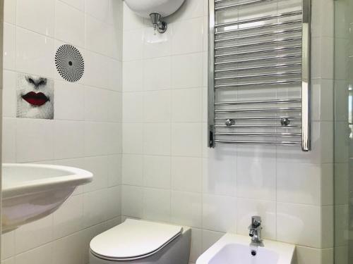 a white bathroom with a toilet and a sink at La Palladiana - Immobilevante in Ponza