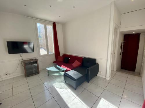 a living room with a couch and a tv at les meublés du soleil in Menton