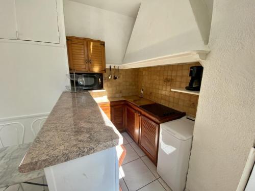 a small kitchen with wooden cabinets and a counter top at les meublés du soleil in Menton