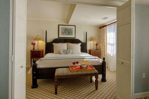 a bedroom with a bed and a table with flowers on it at Saybrook Point Resort & Marina in Old Saybrook