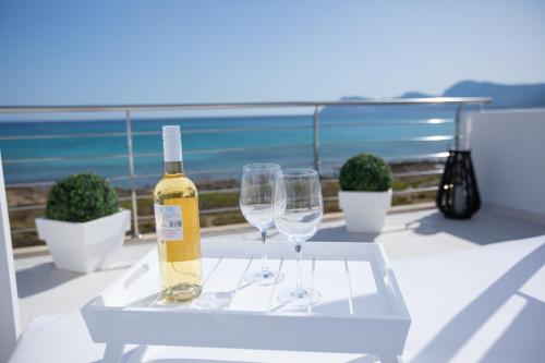 a bottle of wine and two wine glasses on a table at Son Serra Sea Coast Villa in Son Serra de Marina