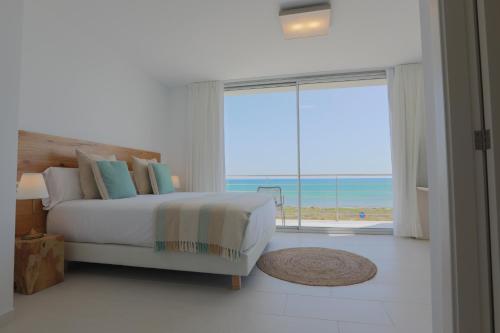a bedroom with a bed and a view of the ocean at Son Serra Sea Coast Villa in Son Serra de Marina