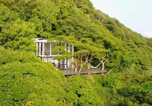 a house in the middle of a hill with trees at Izu Cliff House - Vacation STAY 29217v in Ihama