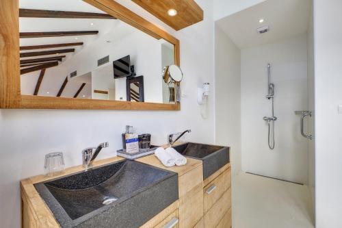 a bathroom with two sinks and a mirror at Dolphin Suites in Veli Lošinj